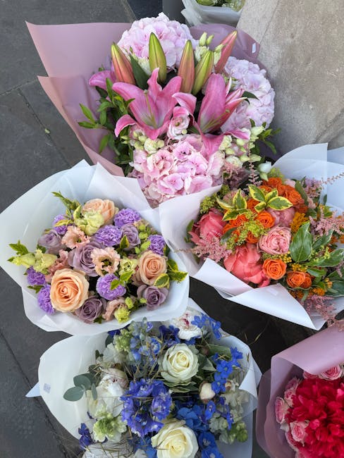 A selection of four floral bouquets arranged with a variety of fresh flowers. The top bouquet features pink lilies with prominent petals and buds, accented by pink hydrangeas, wrapped in light pink pa